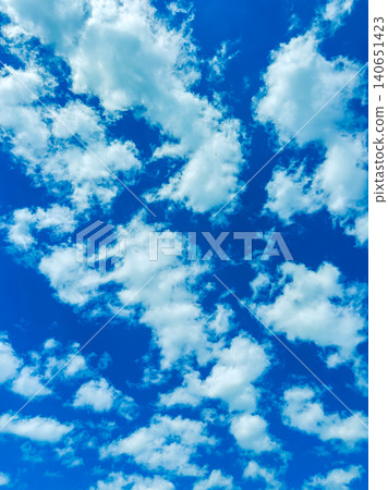 Clouds fill the sky during the day showing various shapes and patterns in a bright blue atmosphere 140651423