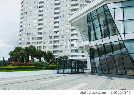 Modern building with unique architecture next to a tall apartment complex in a city on an overcast day during daytime Modern building with unique architecture next to a tall apartment complex in a city on an overcast day during daytime 140651545