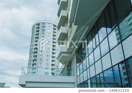 Modern buildings and glass facades present in a city setting under a cloudy sky 140651559