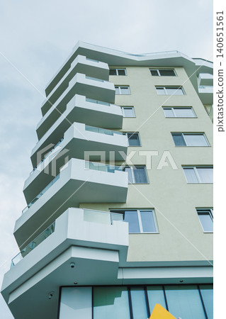 Balconies are seen on a modern building in an urban area showcasing contemporary architecture on a cloudy day Balconies are seen on a modern building in an urban area showcasing contemporary architecture on a cloudy day 140651561