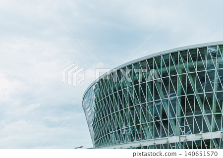 Modern glass building in urban area designed for various events and activities with an interesting architectural style during a cloudy day in the city Modern glass building in urban area designed for various events and activities with an interesting architectural style during a cloudy day in the city 140651570