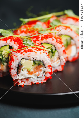 Sushi rolls with fresh ingredients on a dark plate ready for enjoyment at a local Japanese restaurant during evening hours Sushi rolls with fresh ingredients on a dark plate ready for enjoyment at a local Japanese restaurant during evening hours 140651587