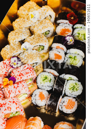 Sushi rolls arranged on a tray with various types and colors at a food event in the evening Sushi rolls arranged on a tray with various types and colors at a food event in the evening 140651611