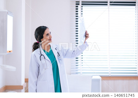 portrait of young medical doctor looking at an x-ray image in the office. portrait of young medical doctor looking at an x-ray image in the office. 140651745