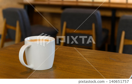 white coffee cup with hot cappuccino coffee on wooden table in coffee cafe. copy space for adding text white coffee cup with hot cappuccino coffee on wooden table in coffee cafe. copy space for adding text 140651757