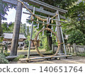 The straw ring and torii gate at the summer purification ceremony, in the lush green shrine grounds (horizontal view) [Omiwa Shrine/Tochigi] 140651764