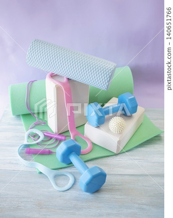 Fitness equipment for home workouts on a wooden floor. Fitness equipment with yoga mat, blocks, dumbbells and massage ball. Fitness equipment for home workouts on a wooden floor. Fitness equipment with yoga mat, blocks, dumbbells and massage ball. 140651766