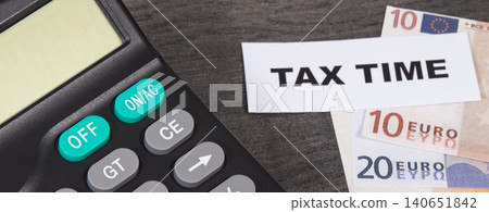 Calculator, inscription tax time and euro banknotes. Time of calculating, return or tax payment 140651842