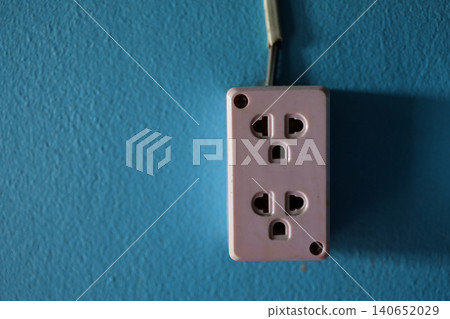 Pink Electrical Power Outlet on Textured Blue Wall with Copy Space 140652029