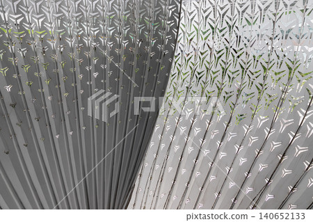 Featuring an intricate, fan-like geometry, the sculpture relies on a central, sinuous partition that gracefully divides the frame. Dozens of metallic, monochromatic ribs radiate outward from this 140652133