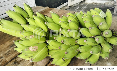 Fresh bunch of green bananas on a rustic wooden table background 140652686