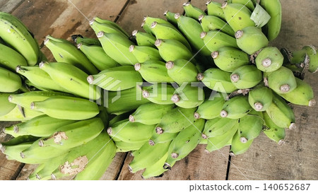 Fresh bunch of green bananas on a rustic wooden table background 140652687