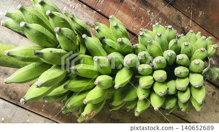 Fresh bunch of green bananas on a rustic wooden table background 140652689