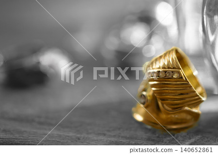 Elegant gold ring with diamonds on dark textured background Elegant gold ring with diamonds on dark textured background 140652861