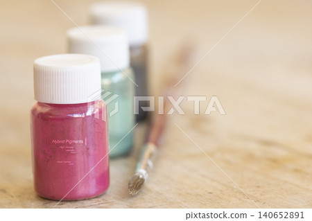Metallic pigment powder bottles with paint brush on wooden table Metallic pigment powder bottles with paint brush on wooden table 140652891