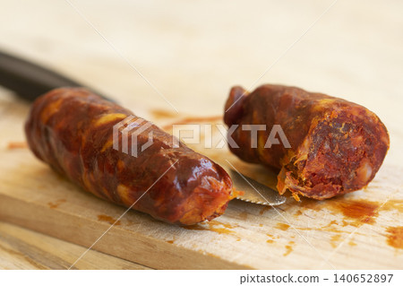 Sliced chorizo sausage close up on rustic wooden cutting board Sliced chorizo sausage close up on rustic wooden cutting board 140652897