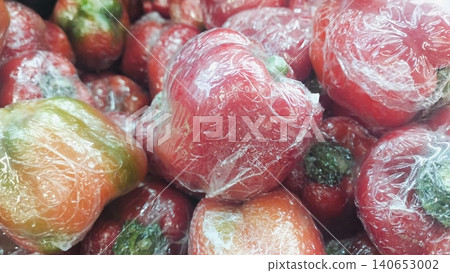 Fresh red bell peppers wrapped in plastic film background at supermarket Fresh red bell peppers wrapped in plastic film background at supermarket 140653002