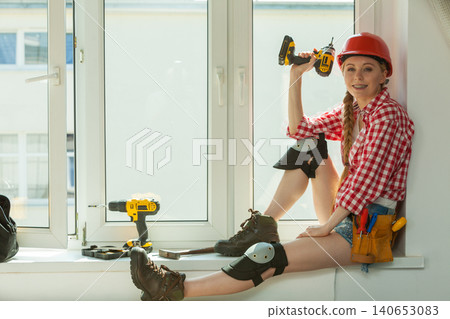 Woman with helmet next to the window Woman with helmet next to the window 140653083