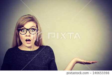 Nerdy woman in eyeglasses being confused Nerdy woman in eyeglasses being confused 140653398