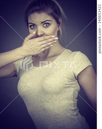 Woman covering her mouth with hand Woman covering her mouth with hand 140653421