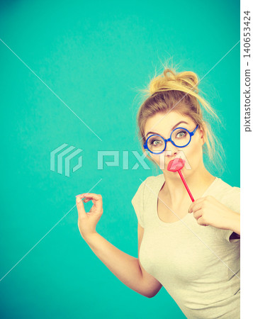 Happy woman holding fake lips on stick Happy woman holding fake lips on stick 140653424