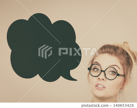 Woman holding black thinking bubble Woman holding black thinking bubble 140653428