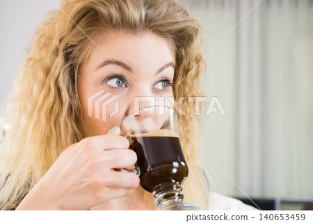 Positive woman drinking her morning coffee 140653459