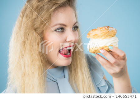 Funny woman holds cream puff cake Funny woman holds cream puff cake 140653471