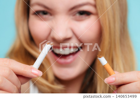 Smilling girl is breaking cigarette Smilling girl is breaking cigarette 140653499