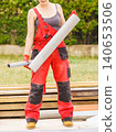 Woman carrying pipes on construction site 140653506