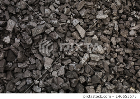 Dark coal piles form a rough mound 140653573