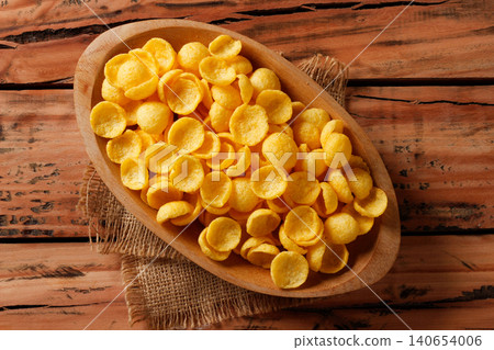 Crispy corn snack chips in wooden serving tray on burlap fabric and rustic wooden table Crispy corn snack chips in wooden serving tray on burlap fabric and rustic wooden table 140654006