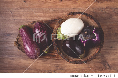 colored eggplants, on a wooden table, white, purple and black eggplants, top view, raw eggplants, without people, colored eggplants, on a wooden table, white, purple and black eggplants, top view, raw eggplants, without people, 140654111