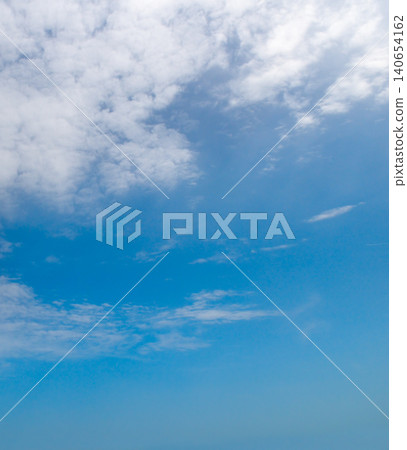 Beautiful bright blue sky with a mixture of soft altocumulus and light cirrus white clouds, serene natural background template, vertical orientation. 140654162