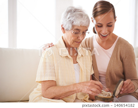 Senior woman, mother and daughter with gift for bonding, appreciation and love relaxing on sofa at home, living room and apartment. Female people, family or looking at jewelry for pearl heirloom Senior woman, mother and daughter with gift for bonding, appreciation and love relaxing on sofa at home, living room and apartment. Female people, family or looking at jewelry for pearl heirloom 140654182