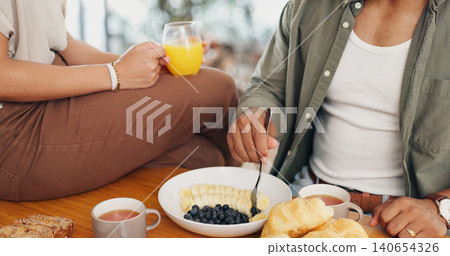 Health, hands and couple eating breakfast with fruit, coffee and juice at table for wellness diet. Food, wellness and closeup of man and woman enjoying brunch meal together in morning at home. 140654326