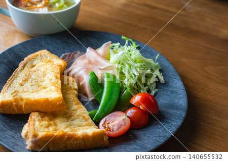 A close-up of a breakfast plate with French toast and fresh salad. A close-up of a breakfast plate with French toast and fresh salad. 140655532