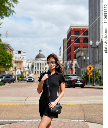 Young Woman in Black Dress Walking on Downtown Jackson Mississippi Street Young Woman in Black Dress Walking on Downtown Jackson Mississippi Street 140655552