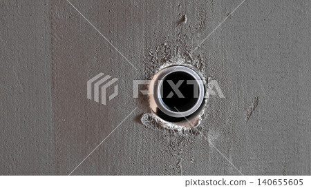 Closeup Concrete Wall With Pipe Opening, Rough Plaster Edges And Metal Sleeve Raw Industrial Texture, Shadowed Surface, Ideal For Construction, Plumbing Inspection, Maintenance Reference Closeup Concrete Wall With Pipe Opening, Rough Plaster Edges And Metal Sleeve Raw Industrial Texture, Shadowed Surface, Ideal For Construction, Plumbing Inspection, Maintenance Reference 140655605