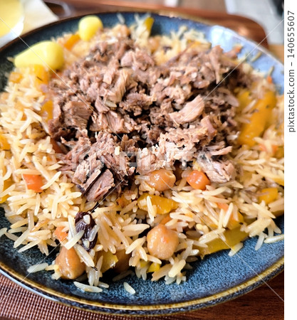 Traditional pilaf with succulent meat, chickpeas, and raisins, served on a plate. 140655607
