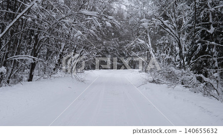 Country Snow Road Alaska Usa Under Muted Light With Tree Canopies Bowed By Heavy Snow, Empty Lane Extends Into Quiet Winter Landscape, Still Mood Ideal For Seasonal Backgrounds 140655632