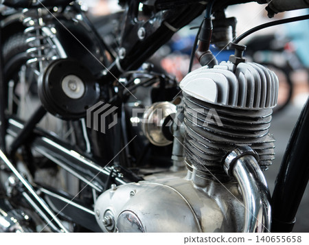 Close Up Vintage Motorcycle Engine Detail Gleaming Chrome Fins And Piston Housing, Oilstreaked Casing, Textured Metal Surfaces, Shallow Depth Of Field With Blurred Workshop Bokeh, Cool 140655658