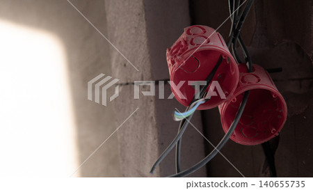 Hanging Red Electrical Boxes In Ceiling During House Construction, Technician Staging Outlets And Routing Cable For Future Fixtures, Soft Light And Shadow Creating Focused Worksite 140655735