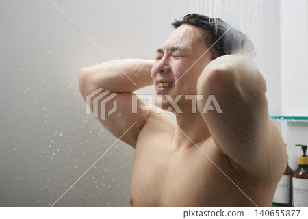 A man in his twenties taking a shower A man in his twenties taking a shower 140655877