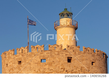 Lighthouse above the medieval Saint Nicholas Fortress at Mandraki Harbor in Rhodes, Greece. Lighthouse above the medieval Saint Nicholas Fortress at Mandraki Harbor in Rhodes, Greece. 140656266