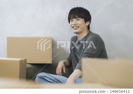 一名年輕男子坐在紙箱堆中；動態影像。 140656412