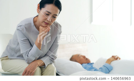 一位昏迷不醒的老人和一位憂心忡忡的女士 140656963