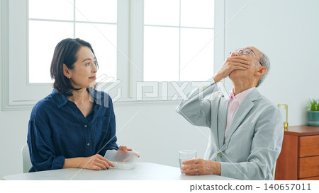 一位女士正在餵一位老人藥。 一位女士正在餵一位老人藥。 140657011