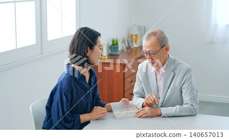一位女士向一位老年男性講解藥物知識。 一位女士向一位老年男性講解藥物知識。 140657013