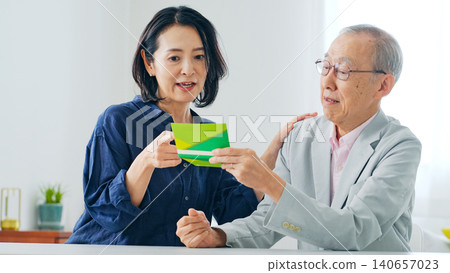 A woman and an elderly man begging for money after looking at a bankbook. 140657023